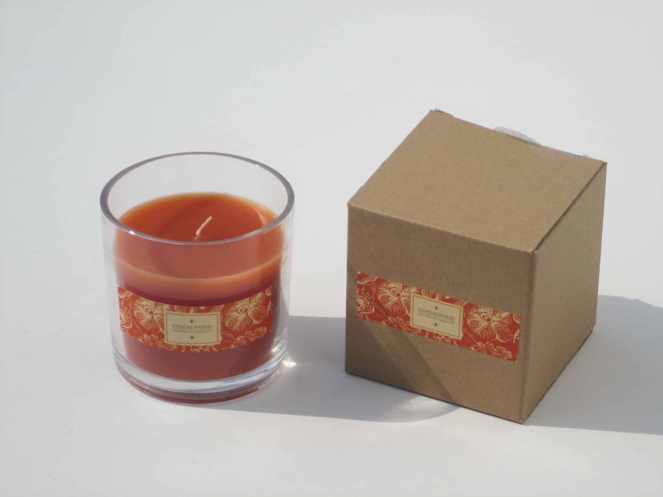 Orange & brown scented glass jar candle with printed label packed into gift box