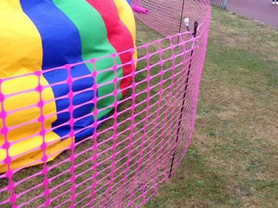 Pink warning barrier fence is used for a carnival.