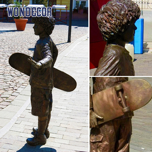 A bronze metal art sculpture of a boy holding a skateboard outdoors