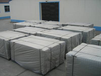 Galvanized welded wire mesh panels on pallet package wrapped in plastic film and with wire tied on the ground in front of the workshop